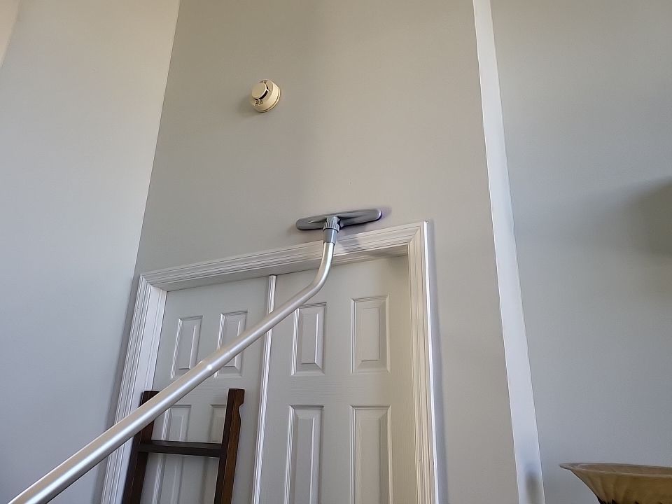 Technician dry sponging soot from wall above door frame after fire damage
